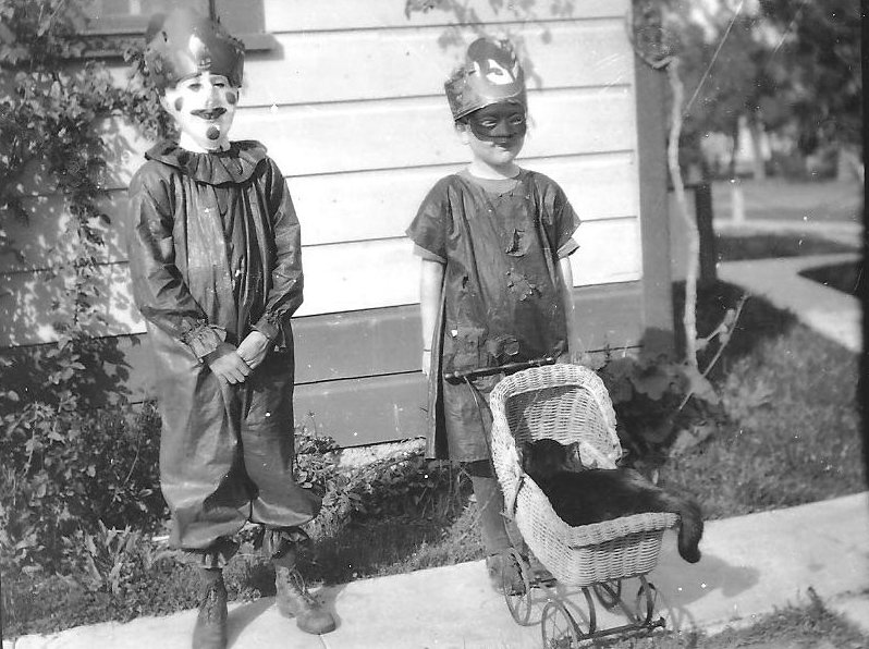 Boy and girl dressed in costume, possibly for Halloween. Black cat in baby doll stroller. Circ. 1920 William S. Borba Collection from Ed Trigiero.