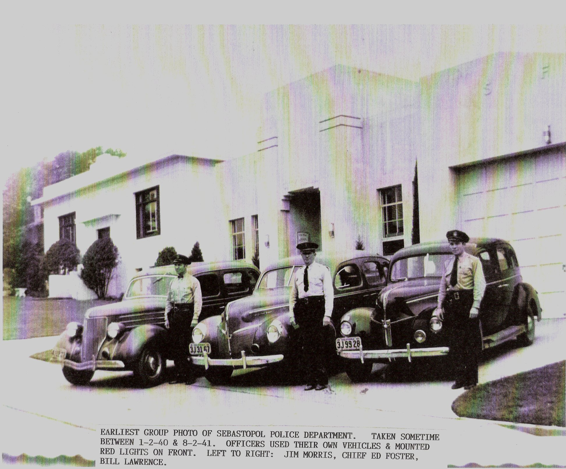 Group photo of Sebastopol Police Department, taken sometime between January 2, 1940 and August 2, 1941. Cars are parked in front of the City Hall and Police Department on Bodega Avenue. Left to right: Jim Morris, Chief Ed Foster and Bill Lawrence. Officers used their own vehicles and mounted red lights on front. L to R: Jim Morris, Chief Ed Foster, Bill Lawrence.